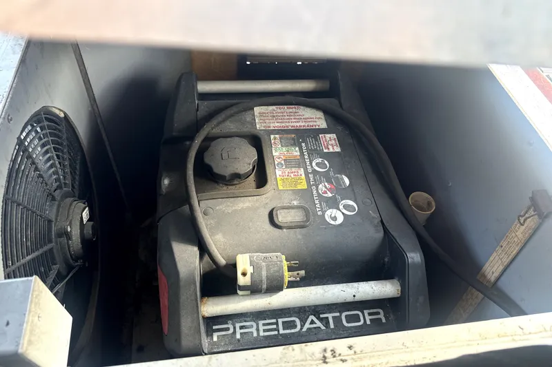 Slide: The Image of Predator generator inside a 1989 Landau 28 Houseboat, next to a ventilation fan. - 22