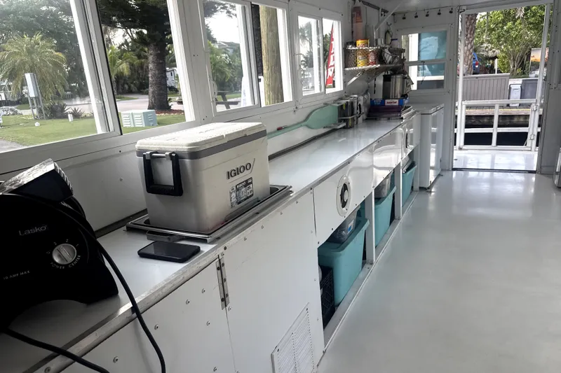 Slide: The Image of Interior of a 1989 Landau 28 Houseboat with kitchen counter and storage bins. - 17