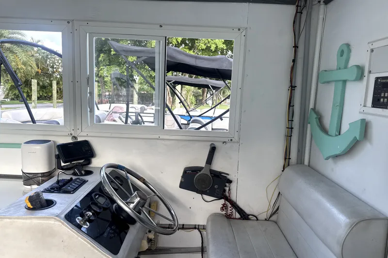 Slide: The Image of Interior of a 1989 Landau 28 Houseboat with steering wheel and anchor decor. - 19