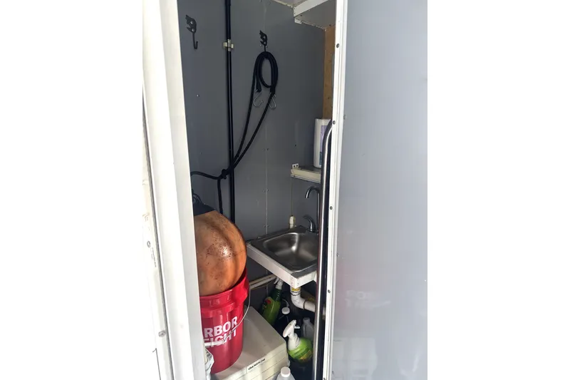 Slide: The Image of Compact utility room in a 1989 Landau 28 Houseboat with sink and storage. - 23