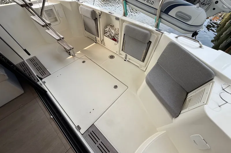 Slide: The Image of 2025 Beneteau Swift Trawler 35 cockpit with seating and ladder, docked by water. - 21