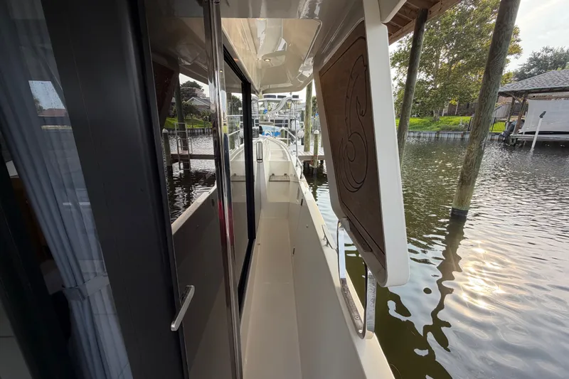 Slide: The Image of 2025 Beneteau Swift Trawler 35 docked, showcasing sleek side deck and modern design. - 14
