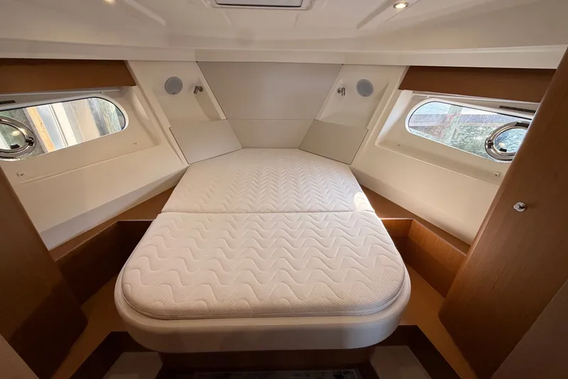 Slide: The Image of 2025 Beneteau Swift Trawler 35 cabin with comfortable bed and porthole windows. - 28
