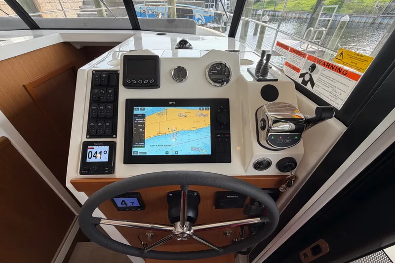 Slide: The Image of 2025 Beneteau Swift Trawler 35 helm with navigation controls and display screen. - 25