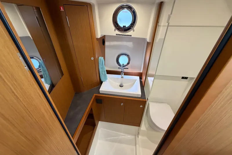 Slide: The Image of Modern bathroom in 2025 Beneteau Swift Trawler 35, featuring wood accents and porthole window. - 32
