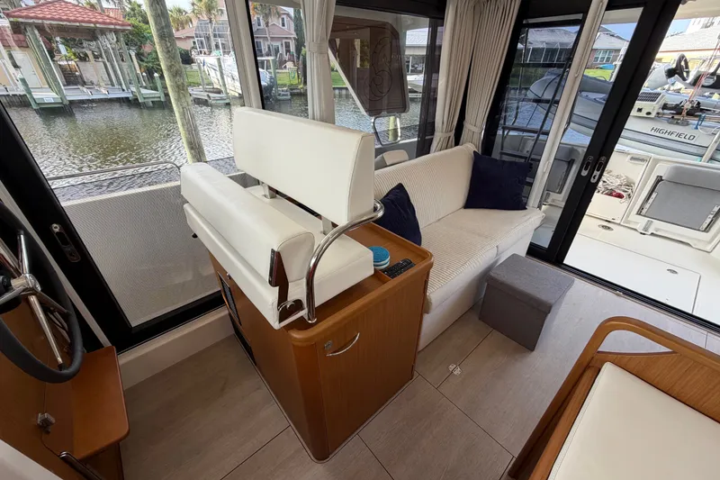 Slide: The Image of Interior of 2025 Beneteau Swift Trawler 35 with seating and helm, dockside view. - 27
