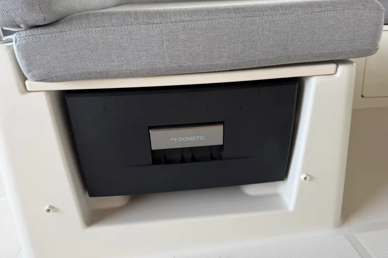 Slide: The Image of Dometic appliance on 2025 Beneteau Swift Trawler 35, under a cushioned seat. - 19
