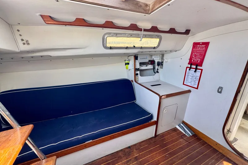 Slide: The Image of Interior of 2000 J Boats J/105 sailboat with blue seating and navigation equipment. - 13