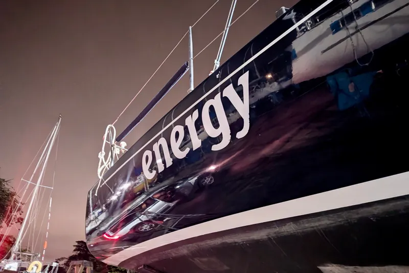 Slide: The Image of 2000 J Boats J/105 sailboat named "Energy" with sleek black hull at night. - 17