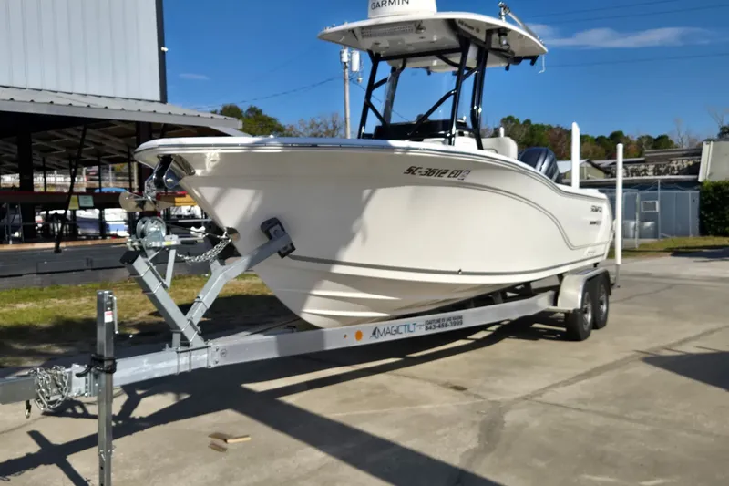 Slide: The Image of 2023 Sea Fox 248 Commander boat on trailer, parked outdoors under clear blue sky. - 32