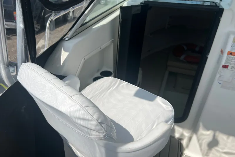 Slide: The Image of 2000 Hydra-Sports 230 Seahorse WA boat interior with white captain's chair and cabin entrance. - 16
