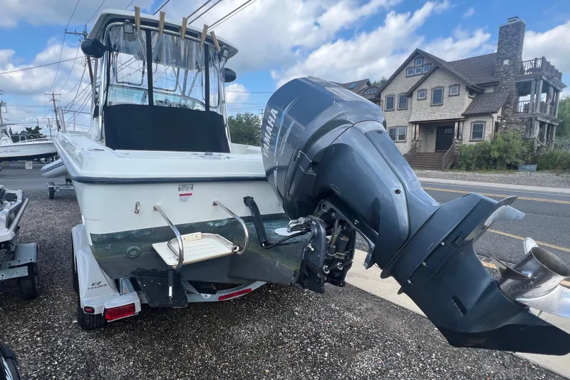 Slide: The Image of 2000 Hydra-Sports 230 Seahorse WA boat with Yamaha outboard motor, parked near a house. - 3