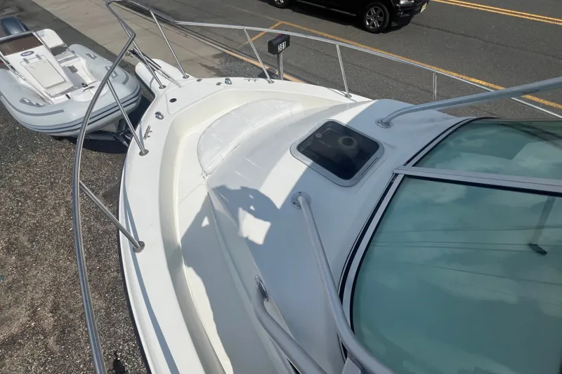 Slide: The Image of 2000 Hydra-Sports 230 Seahorse WA boat deck with railing and hatch, parked on street. - 12