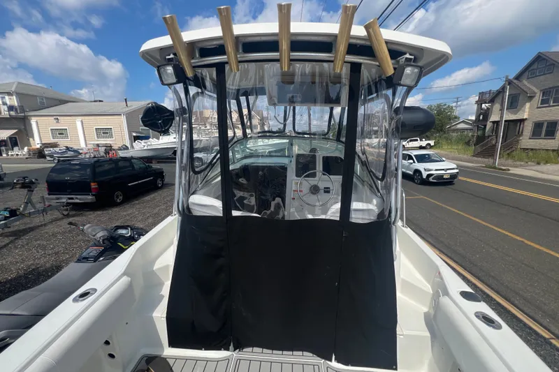 Slide: The Image of 2000 Hydra-Sports 230 Seahorse WA boat with covered helm, parked near coastal buildings. - 11