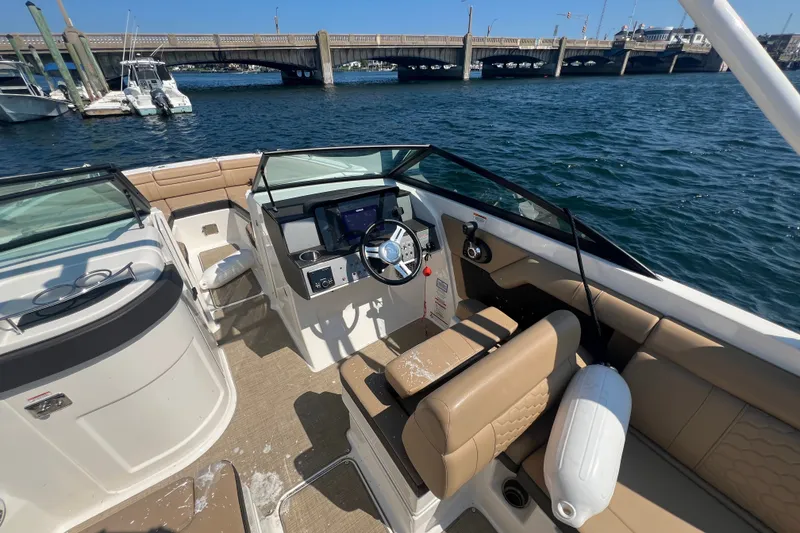 Slide: The Image of 2018 Sea Ray SDX 270 boat interior with helm, beige seating, and waterfront view. - 6