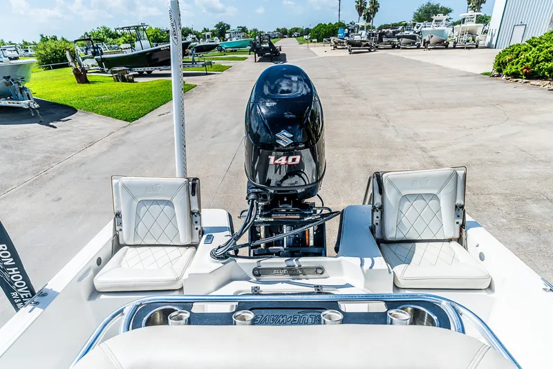 Slide: The Image of A 2018 Blue Wave 1900STL boat with a Suzuki 140 engine, parked on a concrete lot. - 11