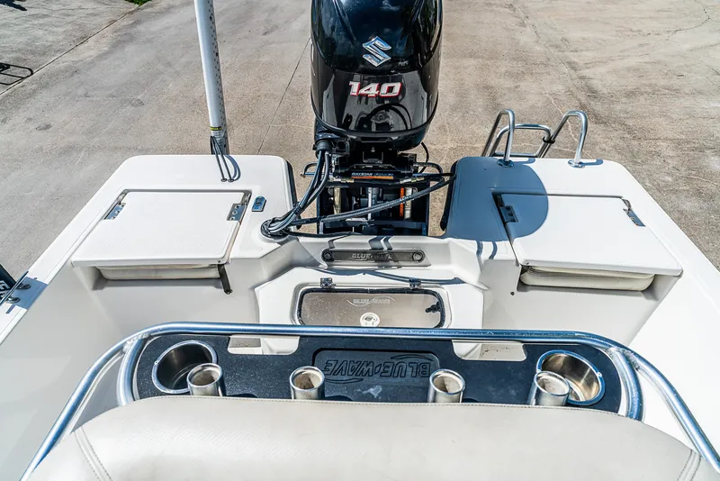 Slide: The Image of The image shows the stern of a 2018 Blue Wave 1900STL boat with a Suzuki 140 engine. - 10
