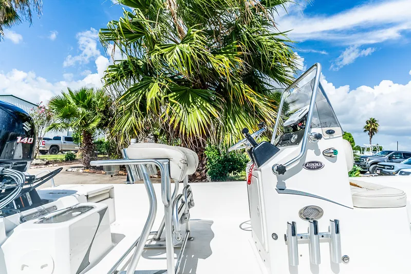 Slide: The Image of A 2018 Blue Wave 1900STL boat with a helm console, surrounded by palm trees and blue sky. - 6