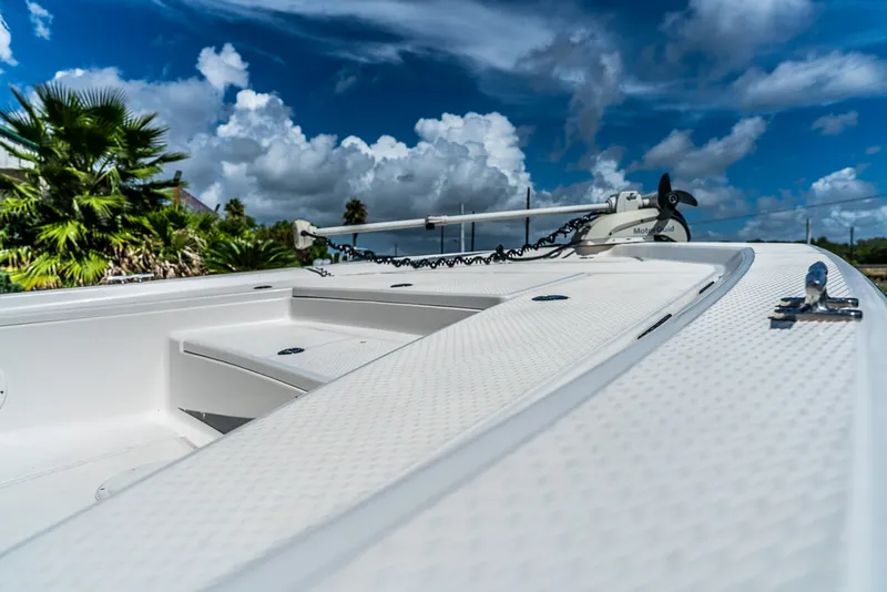Slide: The Image of A 2018 Blue Wave 1900STL boat with a white deck and anchor, surrounded by palm trees and blue sky. - 8