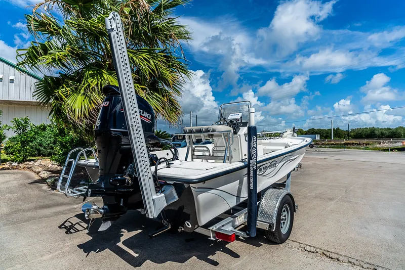 Slide: The Image of A 2018 Blue Wave 1900STL boat on a trailer, featuring an outboard motor and palm trees in the background. - 3
