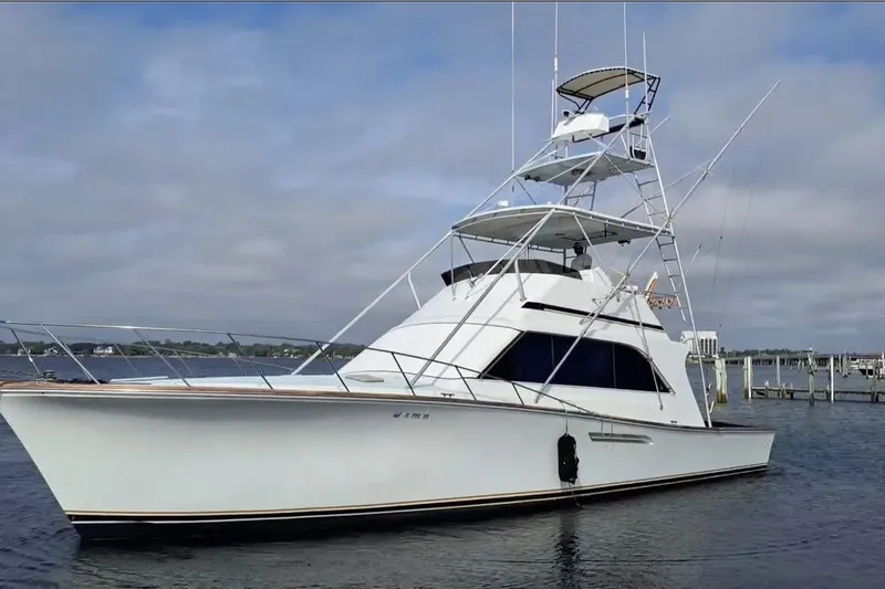 Slide: The Image of 1988 Ocean Yachts 48 Super Sport boat docked on calm water under cloudy sky. - 1