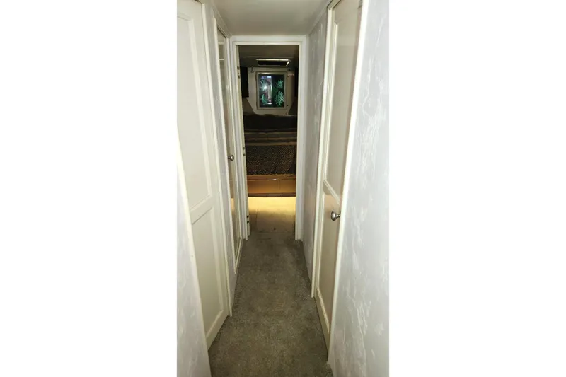 Slide: The Image of Narrow hallway inside 1988 Ocean Yachts 48 Super Sport, featuring white doors and carpet. - 41