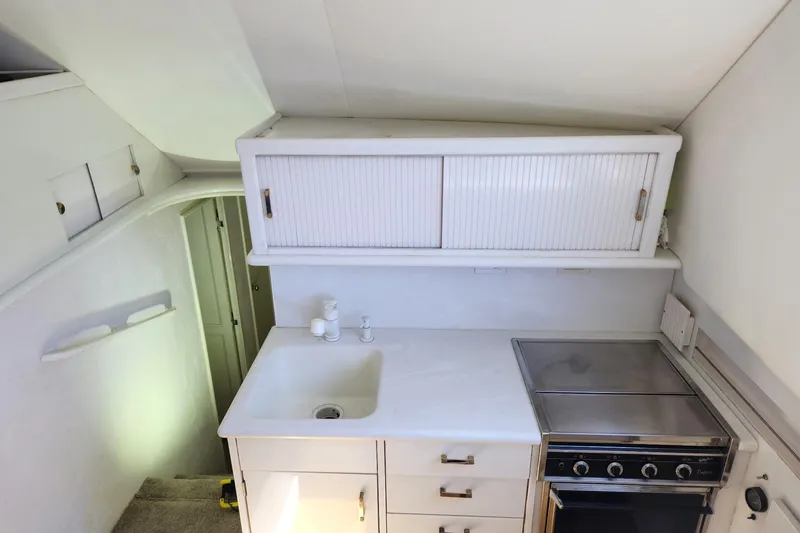 Slide: The Image of 1988 Ocean Yachts 48 Super Sport kitchen with sink, stove, and storage cabinets. - 37