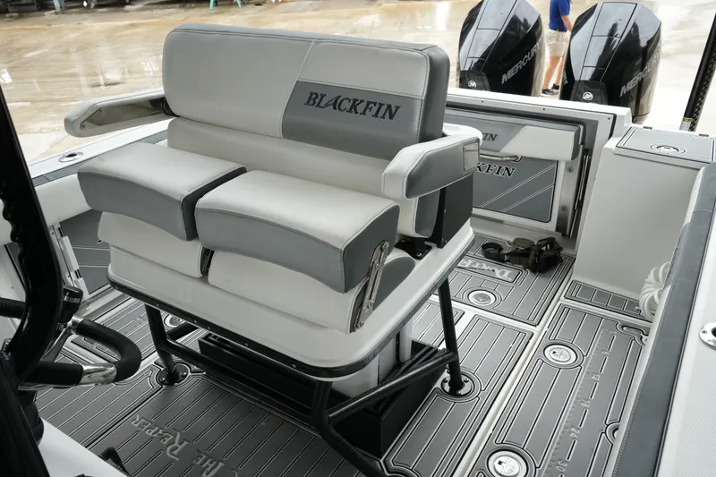 Slide: The Image of 2019 Blackfin 242 CC boat interior with cushioned seating and dual Mercury engines. - 23