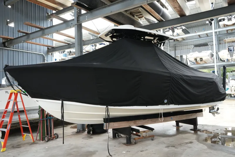 Slide: The Image of 2019 Blackfin 242 CC boat covered in black tarp, stored indoors on a stand. - 27