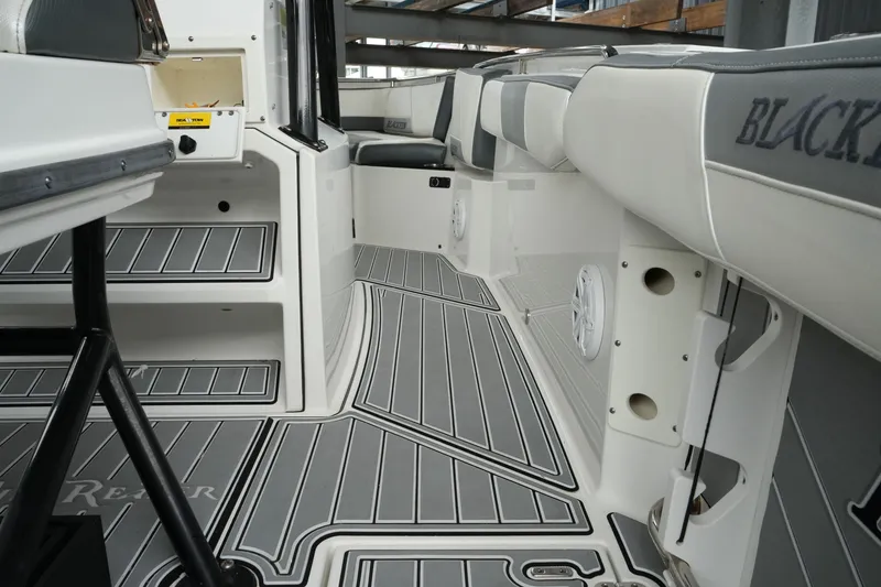 Slide: The Image of Interior view of a 2019 Blackfin 242 CC boat, featuring sleek seating and flooring. - 33