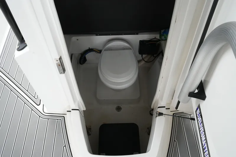 Slide: The Image of Interior view of a 2019 Blackfin 242 CC boat's compact marine toilet area. - 45