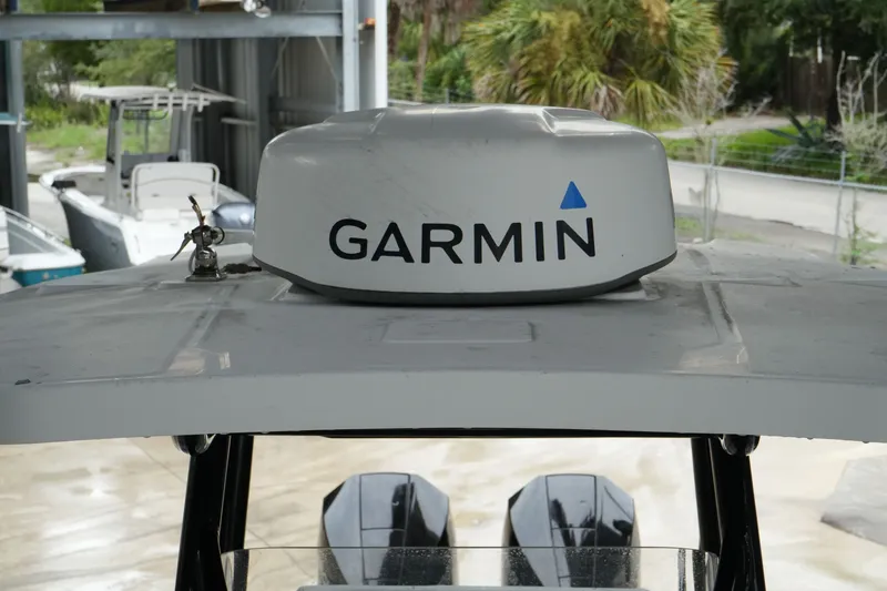 Slide: The Image of 2019 Blackfin 242 CC boat with Garmin radar, parked in a marina setting. - 43