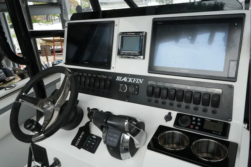 Slide: The Image of 2019 Blackfin 242 CC boat dashboard with steering wheel, dual Garmin displays, and control panel. - 38