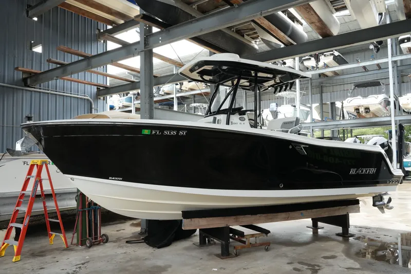The Image of 2019 Blackfin 242 CC boat in storage, black hull, indoor facility. - 0