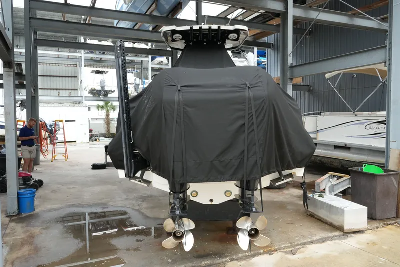 Slide: The Image of 2019 Blackfin 242 CC boat covered in black tarp, stored in a marina. - 54