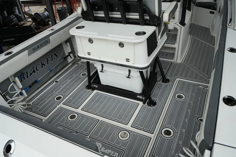 Slide: The Image of 2019 Blackfin 242 CC boat interior with sleek, modern deck design and fishing equipment. - 31