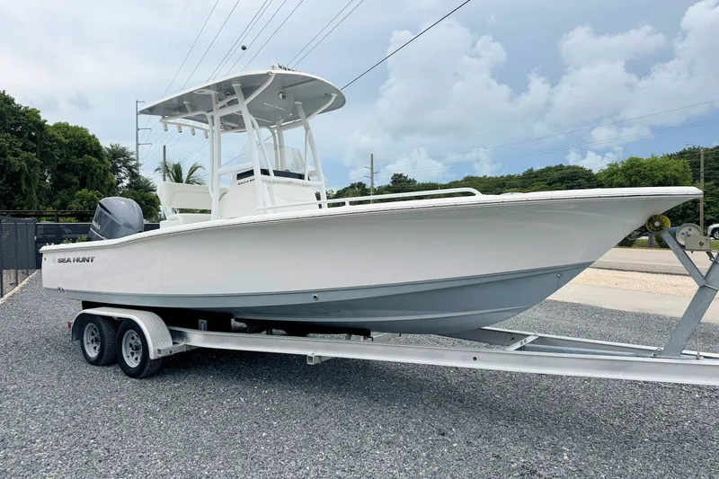 The Image of 2014 Sea Hunt BX24BR boat on trailer, parked outdoors under cloudy sky. - 1