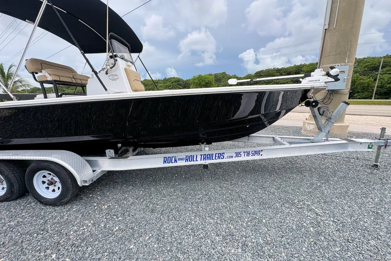 Slide: The Image of 2019 Sportsman Tournament 214 SBX Bay Boat on trailer, parked on gravel. - 5