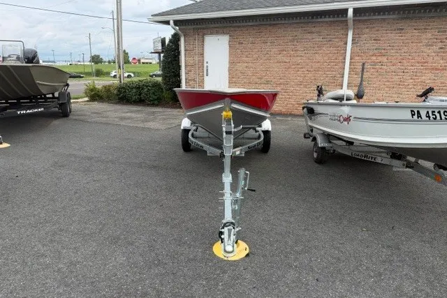 Slide: The Image of 2025 Lund WC-12 boat on trailer, parked outdoors near brick building. - 5