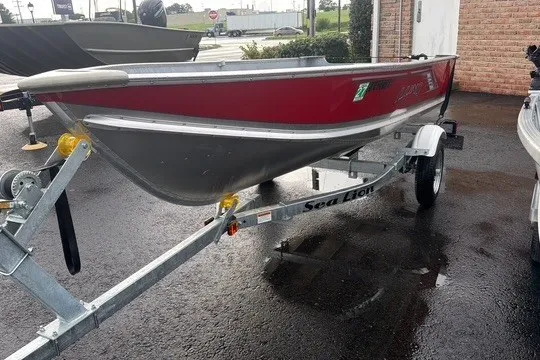 Slide: The Image of 2025 Lund WC-12 boat on Sea Lion trailer, parked on wet pavement. - 9