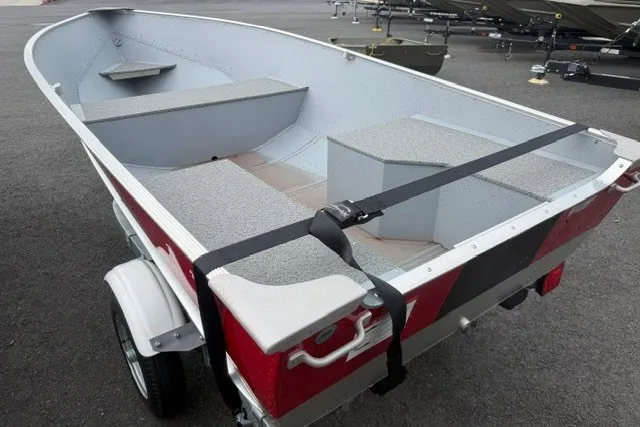 Slide: The Image of 2025 Lund WC-12 boat on trailer, gray interior, red exterior, parked on asphalt. - 6