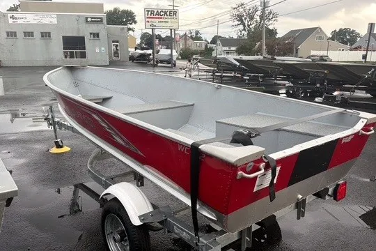 Slide: The Image of 2025 Lund WC-12 boat on trailer in outdoor dealership lot. - 11