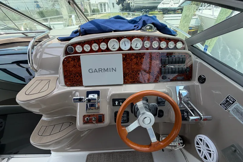 Slide: The Image of 2004 Wellcraft 3700 Martinique helm with Garmin navigation, wood accents, and modern controls. - 17