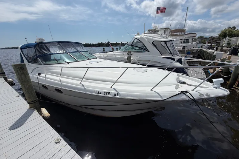 Slide: The Image of 2004 Wellcraft 3700 Martinique boat docked at marina, clear sky, American flag visible. - 4