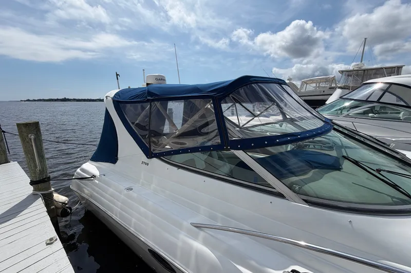 Slide: The Image of 2004 Wellcraft 3700 Martinique yacht docked, featuring blue canopy and sleek design. - 5