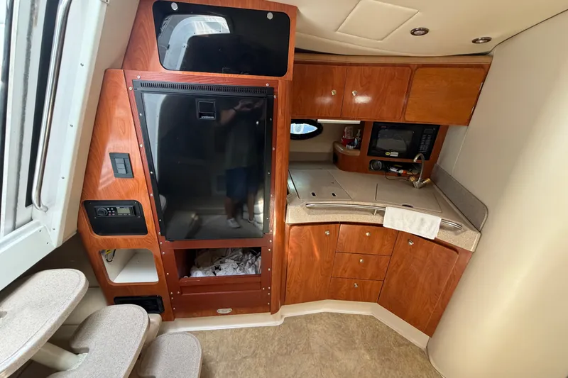 Slide: The Image of 2004 Wellcraft 3700 Martinique yacht interior with kitchenette and wooden cabinetry. - 19