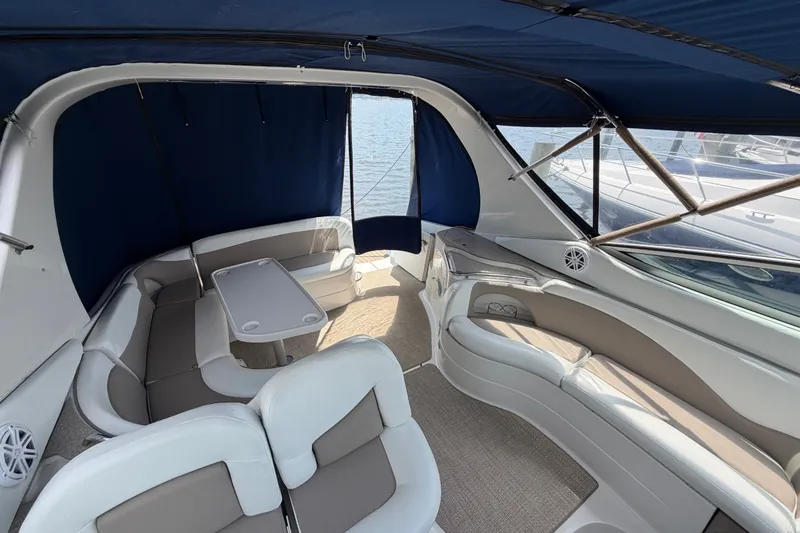 Slide: The Image of 2004 Wellcraft 3700 Martinique boat interior with seating and table, featuring blue canopy. - 12