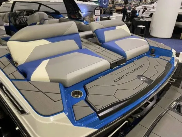 Slide: The Image of The image shows the rear of a 2023 Centurion Ri245 boat with blue and gray upholstery. - 6