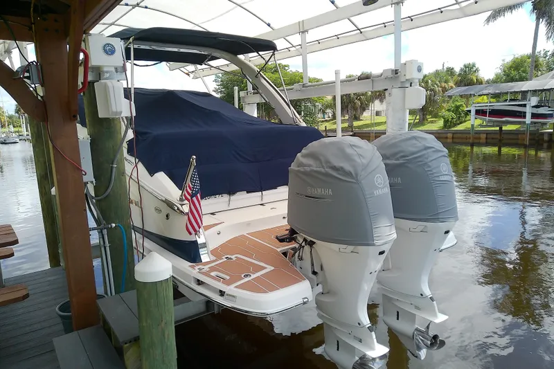 Slide: The Image of 2019 Regal 29 OBX boat docked with Yamaha outboard motors, covered and moored. - 7