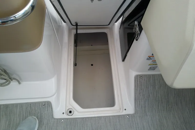 Slide: The Image of Open storage compartment on 2019 Regal 29 OBX boat, featuring clean interior and secure latch. - 45